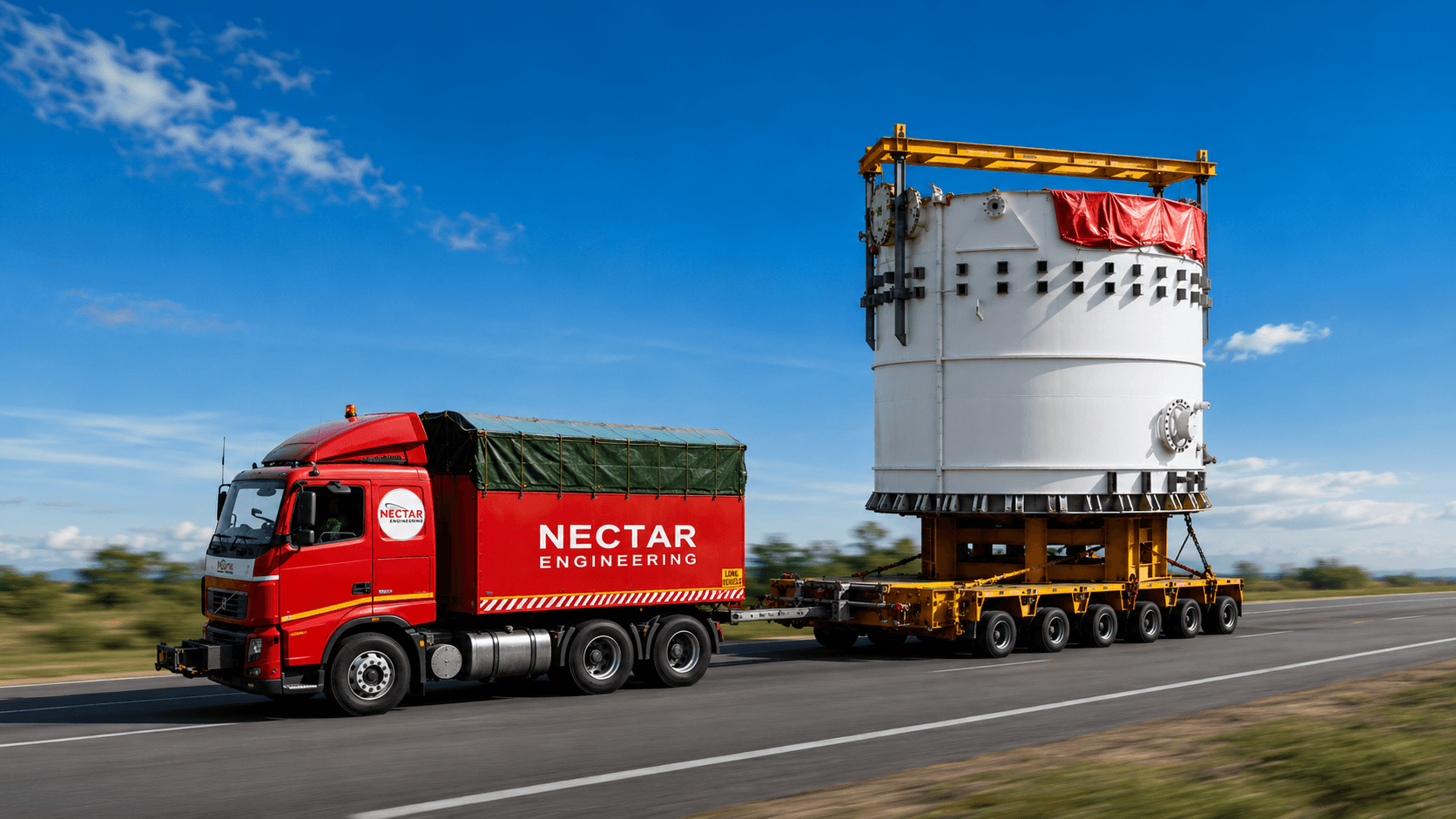 A completed large-diameter process vessel being transported to site on a multi-axle trailer